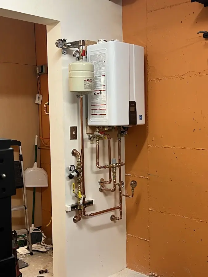 Plumbing technician inspecting water heater connections in Halfway